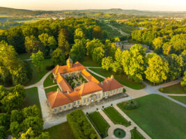 Blick von oben auf das Alte Schloss Eremitage, umrahmt von der grünen Parkanlage