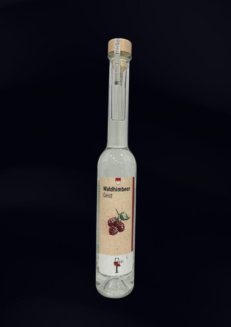 Eine hohe, klare Glasflasche mit der Aufschrift Waldhimbeer Geist, einer Abbildung von Himbeeren, einem Korkverschluss und einem schmalen Hals wird vor einem schlichten schwarzen Hintergrund präsentiert - exklusiv im Bayreuth Shop erhältlich.