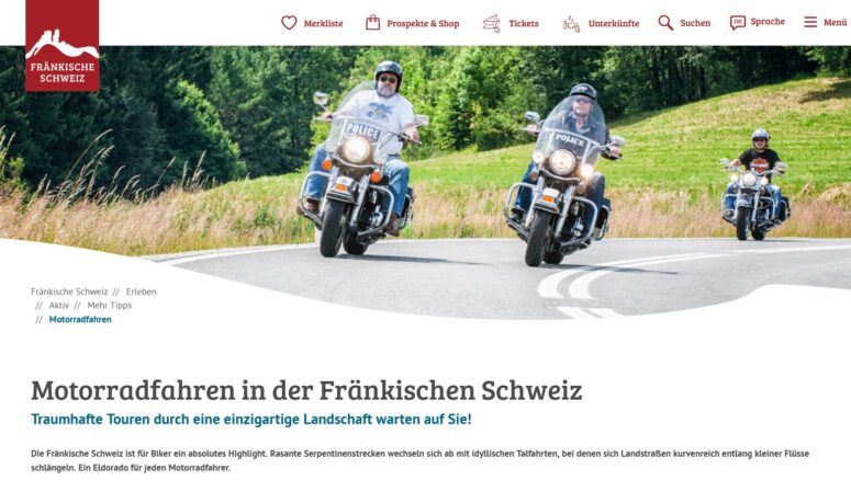 Drei Personen genießen Motorradfahren auf großen Motorrädern entlang einer kurvenreichen Landstraße in der Fränkischen Schweiz, umgeben von grünem Gras und Bäumen. Das sonnige Wetter und ihre Helme und Sonnenbrillen tragen zu diesem malerischen Abenteuer bei.
