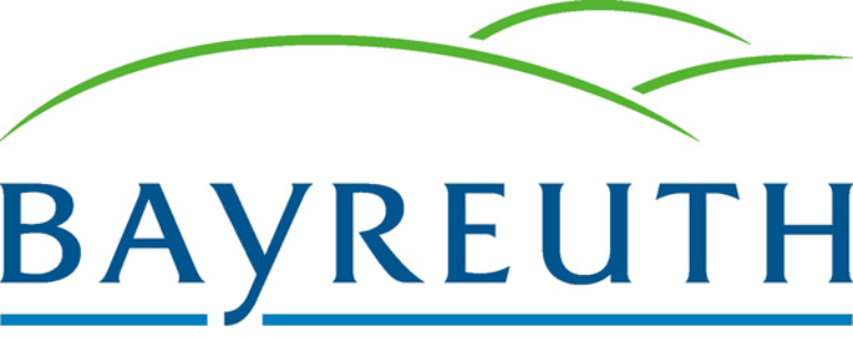 Das Bayreuther Logo zeigt den Schriftzug „BAYREUTH“ in fetten blauen Buchstaben, über denen sich zwei grüne, geschwungene Linien wölben, die Hügel oder eine Landschaft darstellen – ein Verweis auf das Engagement der Stadt für umweltfreundliche Initiativen wie „STADTRADELN“.