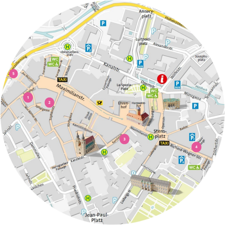 Runder Stadtplan mit abgebildeten Orientierungspunkten: Gebäude, Taxistände, Parkschilder, Toiletten sowie nummerierte rosa Punkte, die verschiedene Orte entlang der Straßen kennzeichnen. Wege, Plätze, Parks und sehenswerte Orte für Kleinkunstvorstellungen sind ebenfalls im gesamten Gebiet verzeichnet.