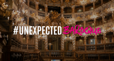 Prunkvolles Theaterinterieur im Barockstil mit goldenen Verzierungen und Balkonen; darüber steht der Text #UNEXPECTED BAROQUE, wobei das Wort „BAROQUE“ in fetten rosa Buchstaben geschrieben ist.