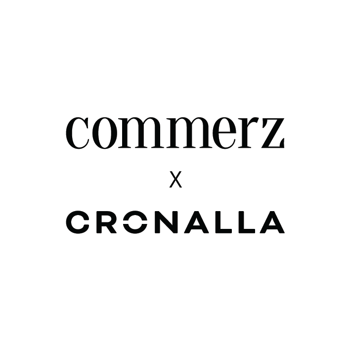 Auf weißem Hintergrund steht in schwarzer Schrift „commerz x CRONALLA“, wobei „commerz“ in einer serifenbetonten Kleinbuchstaben-Schriftart und „CRONALLA“ in einer fetten Großbuchstaben-Schriftart geschrieben ist, getrennt durch ein kleines „x“.