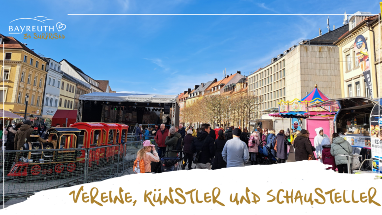 Auf einem Stadtplatz versammelt sich eine Menschenmenge zu einem Faschingsumzug, bei dem ein kleiner roter Kinderzug, eine Bühne und ein Karussell zu sehen sind; am unteren Bildrand ist der Schriftzug Vereine, Künstler und Schausteller eingeblendet.