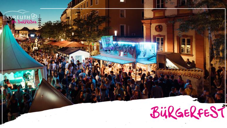 Ein gut besuchtes Straßenfest im Freien in der Abenddämmerung, mit von Leuchtreklamen beleuchteten Imbissständen und dem Schriftzug BÜRGERFEST in der Ecke.