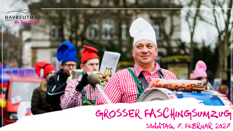 Ein Mann mit Kochmütze und rotem Karohemd spielt während eines Faschingsumzugs auf einer Trommel; dazu steht der Text Großer Faschingsumzug, Sonntag, 7. Februar 2027.