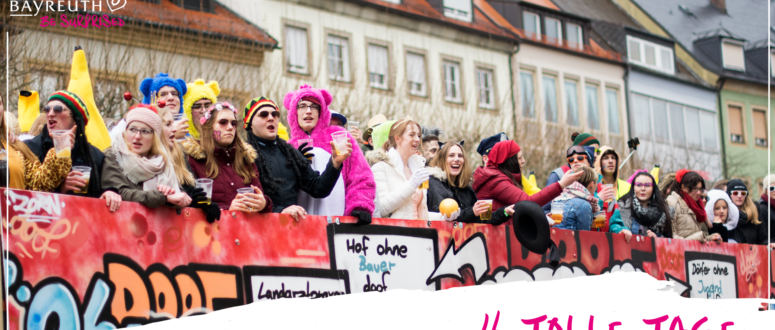 Eine Gruppe von Menschen in Kostümen und mit Hüten steht auf einem roten, mit Graffiti verzierten Festwagen, hält Getränke in den Händen und lächelt; unten rechts ist der Schriftzug 4 TOLLE TAGE zu sehen.